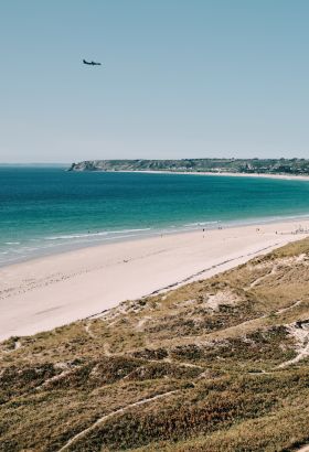 Aerial view of a long sweeping beach, sea and sand dunes