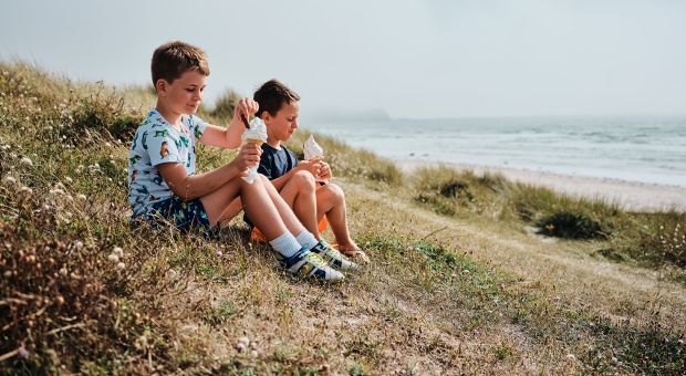 children eating ice cream sitting on the sand dunes