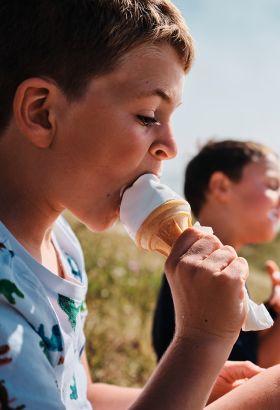 Two young boys eating Jersey Dairy Ice Cream by the beach
