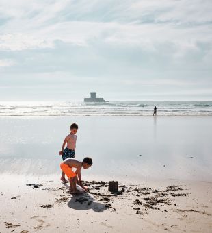 Two young boys building sandcastles on St. Ouen