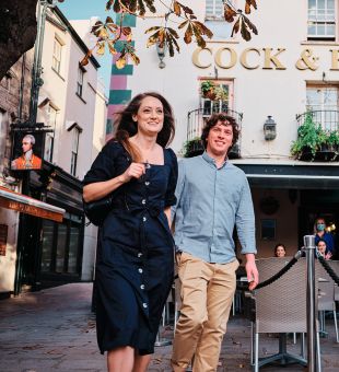 A couple walk past the Cock and Bottle Pub in St. Helier Jersey