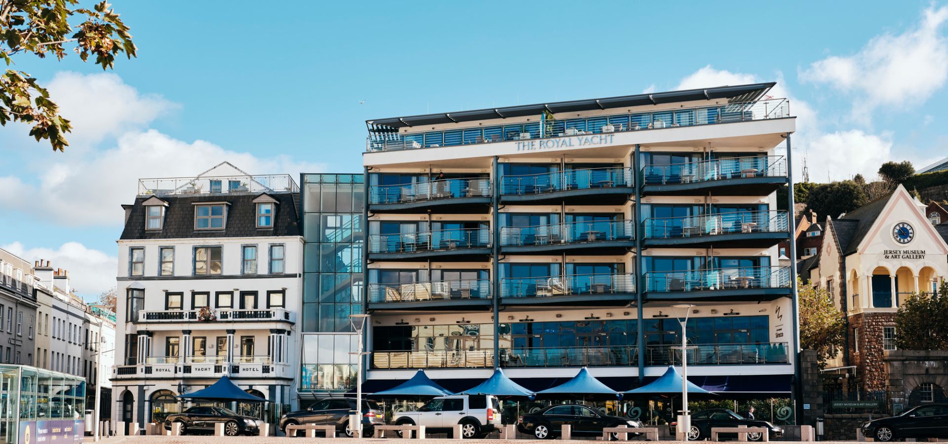 Modern hotel next to an older hotel with blue skies
