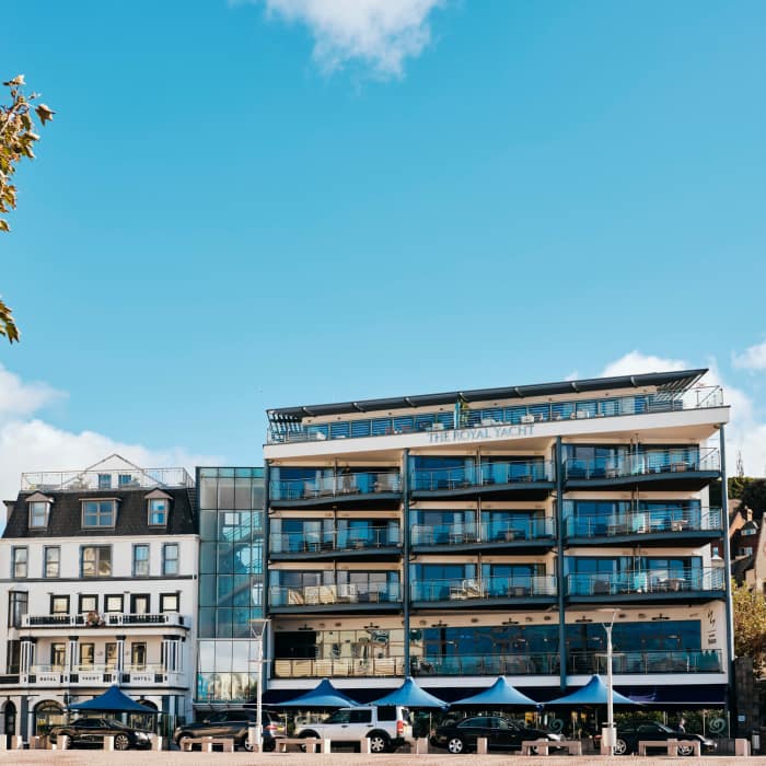 Modern hotel next to an older hotel with blue skies