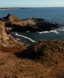 A lady walking on the west coast of Jersey with the view of St. Ouen