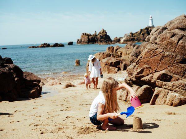 Mother and two young daughters on a golden sandy beach