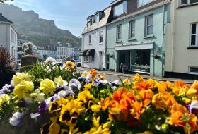 Colourful flowers in front of the green building that is the Seahorse coffee shop.