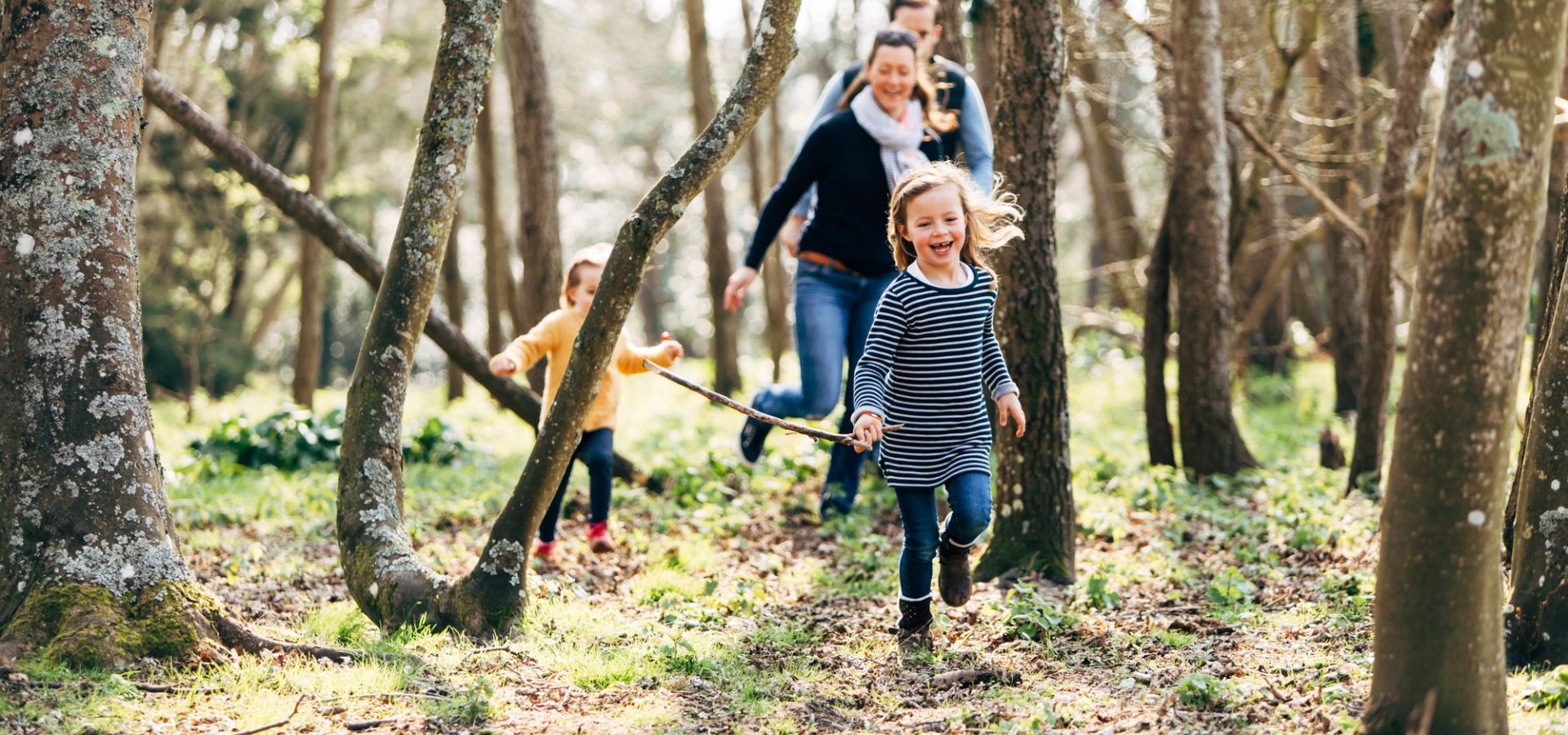 A family playing in woodlands in Jersey