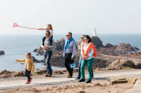 A family walking in front of Corbière Lighthouse