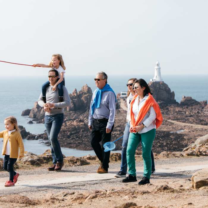 A family walking in front of Corbière Lighthouse