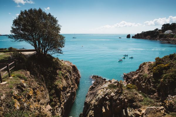 A group of kayakers paddling in the sea around from St. Brelade