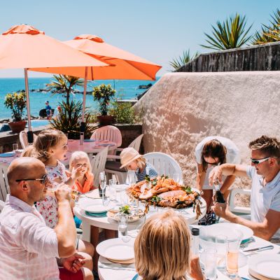A family enjoying a seafood lunch on the terrace at Green Island Restaurant, Jersey