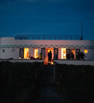 A view of Barge Aground at night - a Jersey Heritage self catering holiday let shaped like a boat that sits right next to St. Ouen