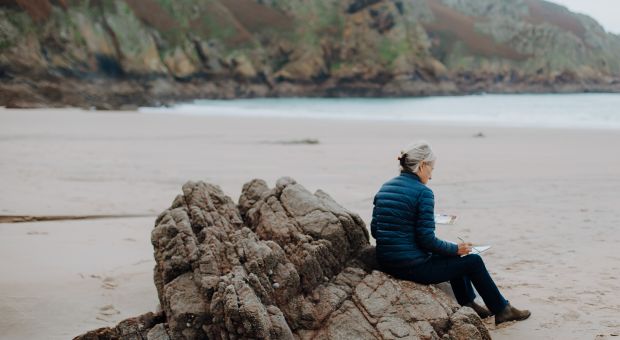 A lady taking part in an arts workshop on Plemont beach