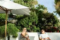 Young couple laying on sun loungers at The Atlantic Hotel, Jersey