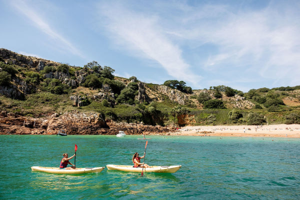 Two women on paddleboards in open sea water