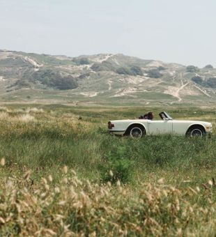 car driving in front of sand dunes