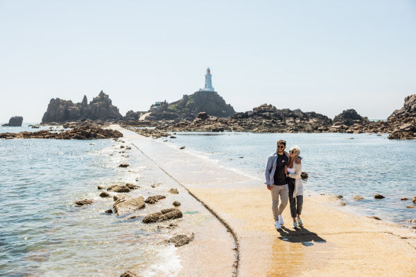 Couple walking the causeway at Corbiere lighthouse