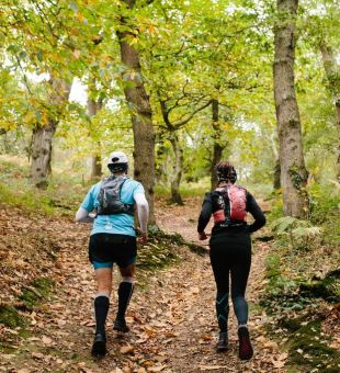 two people running through the woods