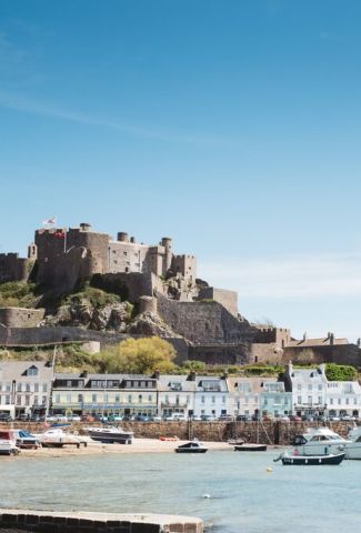 Looking towards Mont Orgueil Castle in Jersey, with Gorey Harbour and boats in the foreground