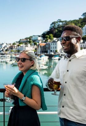 Group of friends enjoying a drink overlooking the harbour in St. Aubin, Jersey