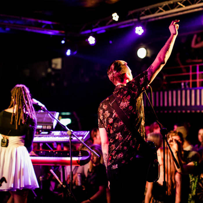 A band on stage at the watersplash performing to a full crowd.