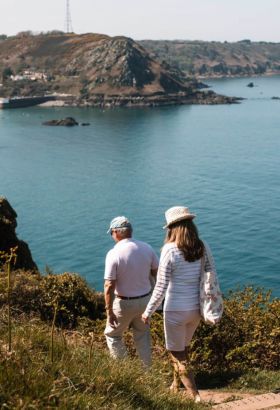 Two people walking down steps of the north coast cliff path trail