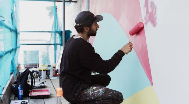 The artist Bokra painting a mural in St. Helier