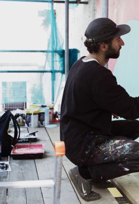 The artist Bokra painting a mural in St. Helier