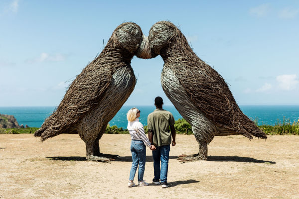 Young couple admiring the puffin sculptures at Plemont, Jersey