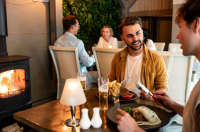 Couple enjoying a meal in front of the fire at Rozel Pub and Dining, Jersey