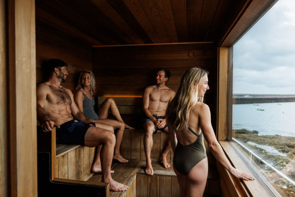 Group of friends in a sauna overlooking the sea
